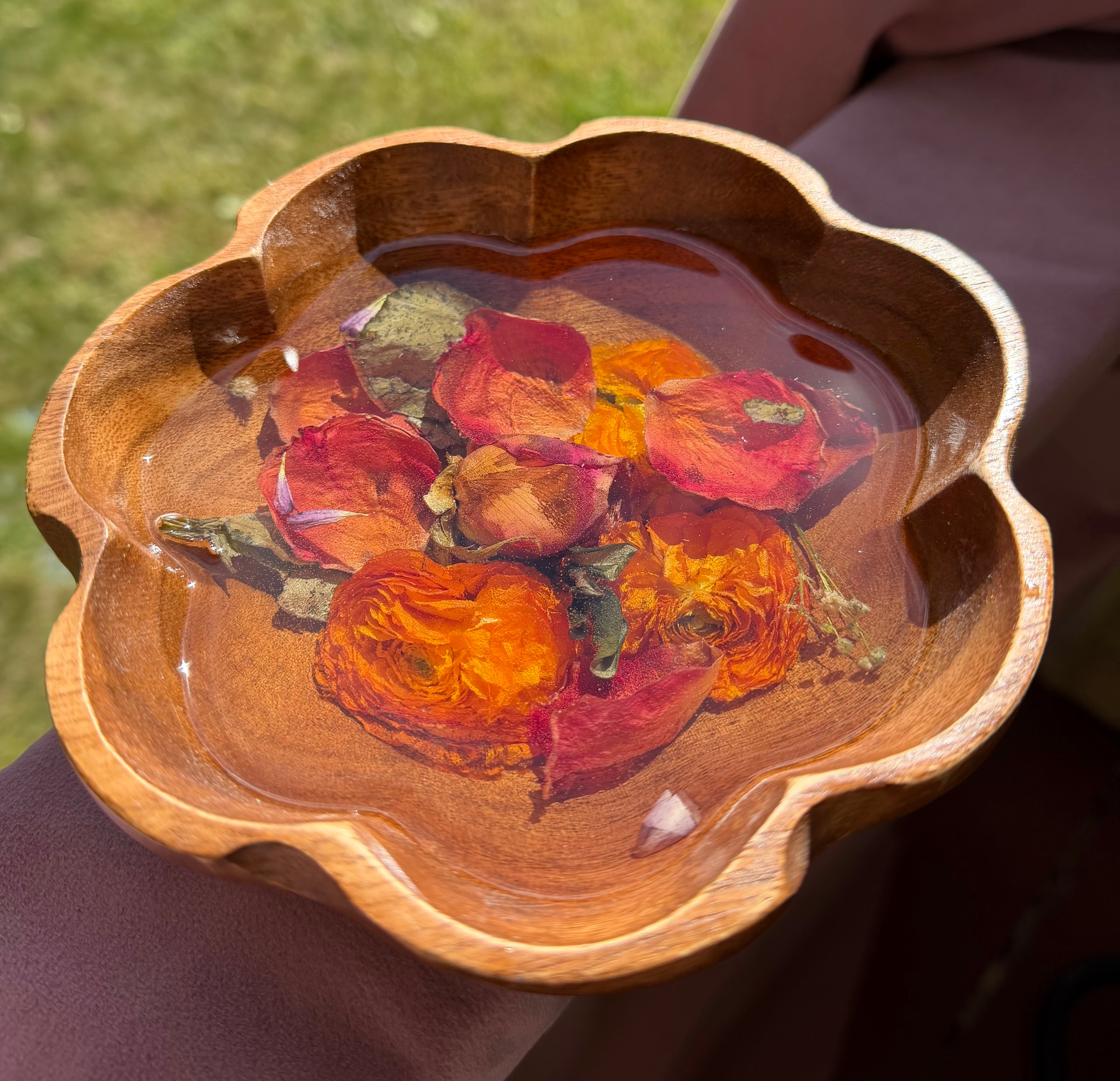 Small scalloped wooden bowl with dried red and orange roses set in clear resin