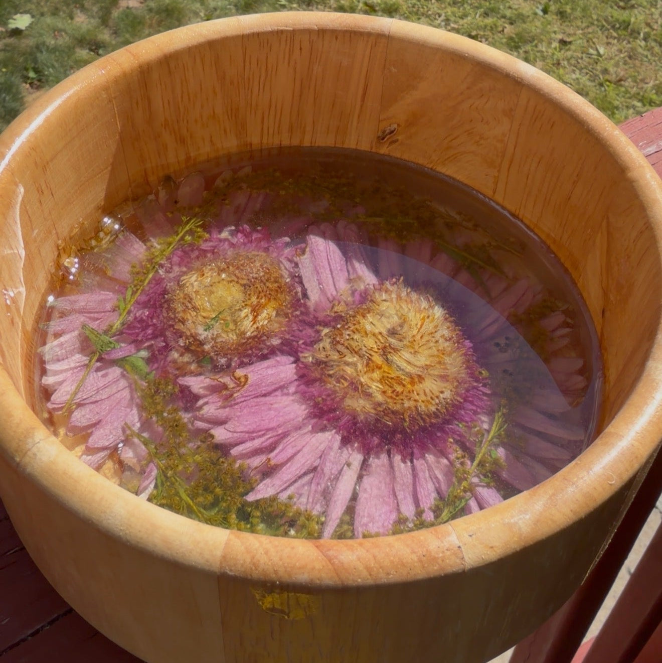 Round light bamboo bowl with two soft pink coneflowers set in clear resin